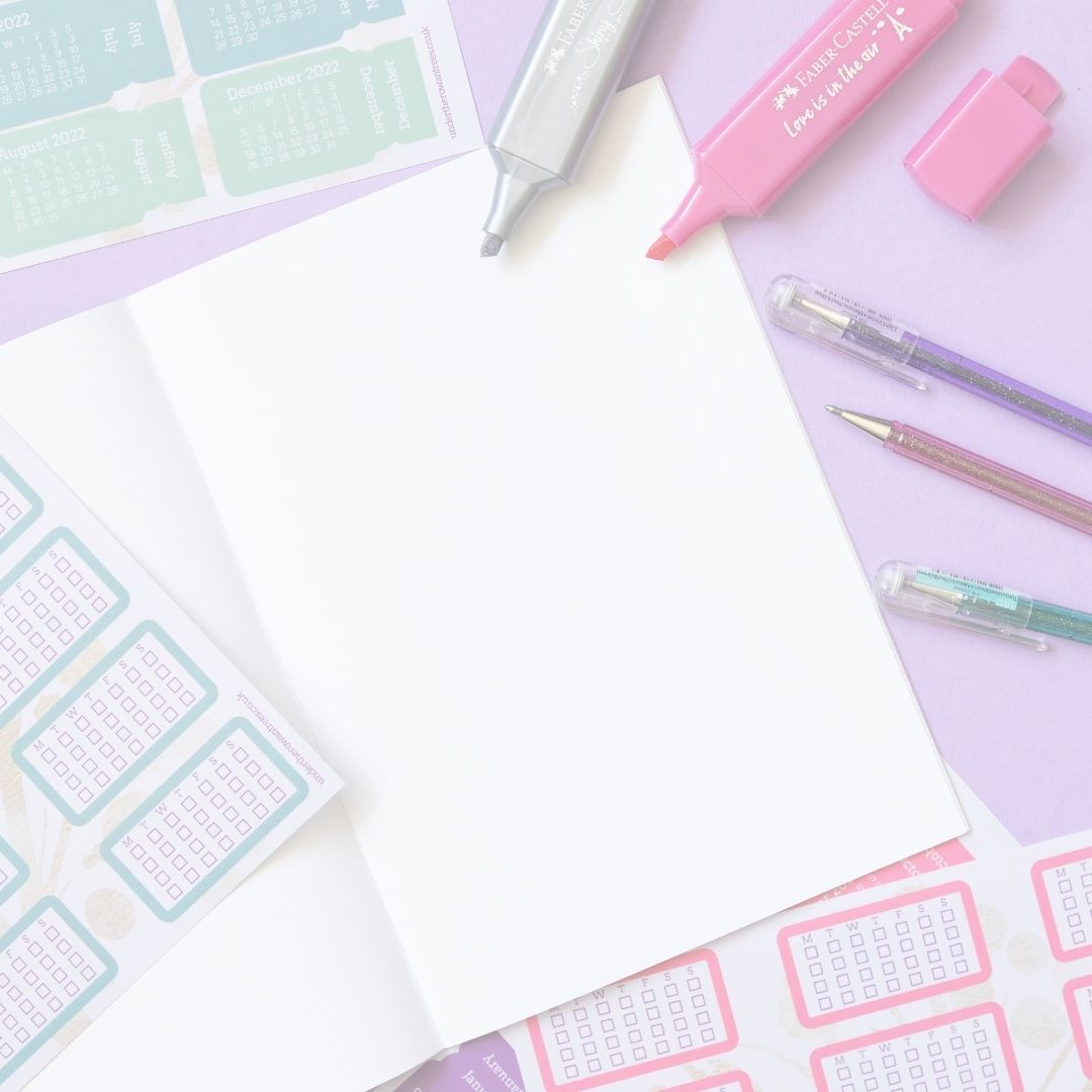 Colourful stationery items, including markers and stickers on a light purple background