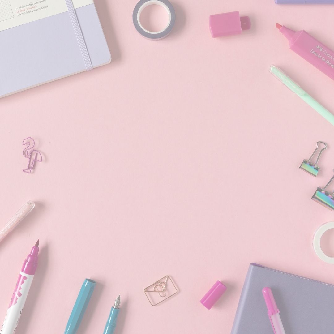 Assorted stationery items on a pink background