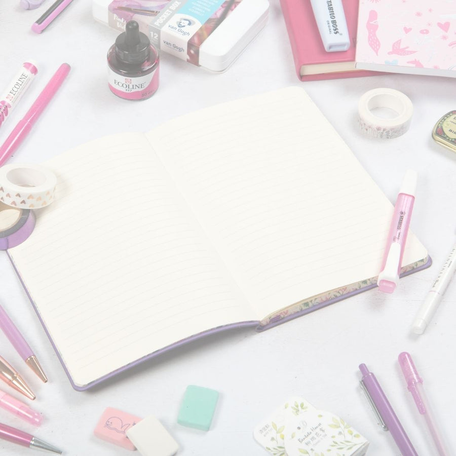 Assorted stationery items including pens, markers, and a lined notebook on a white background