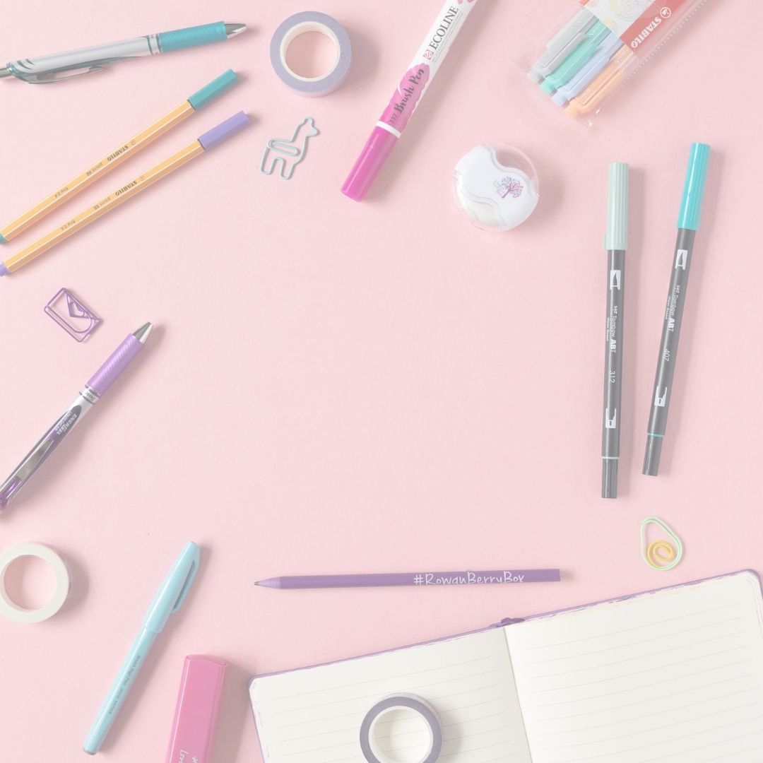 Assorted stationery items including pens, markers, and tape on a pink background