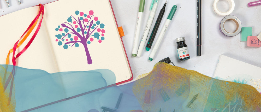 Under the Rowan Trees logo on an open notebook surrounded by stationery items.