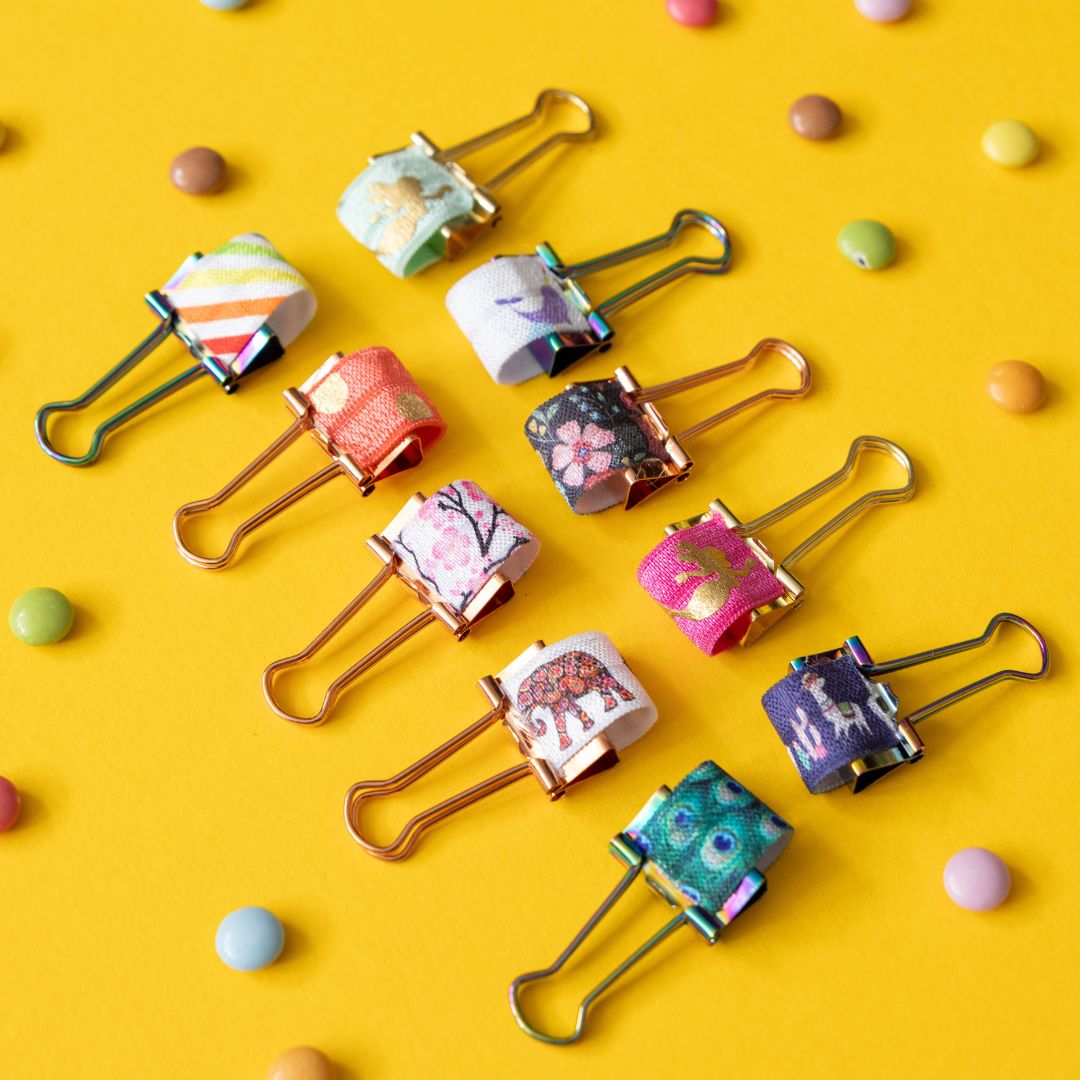 Colourful elasticated pen clips with floral designs on a yellow background