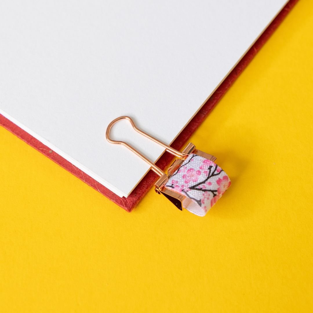 Decorative paper clip with floral design on a yellow background