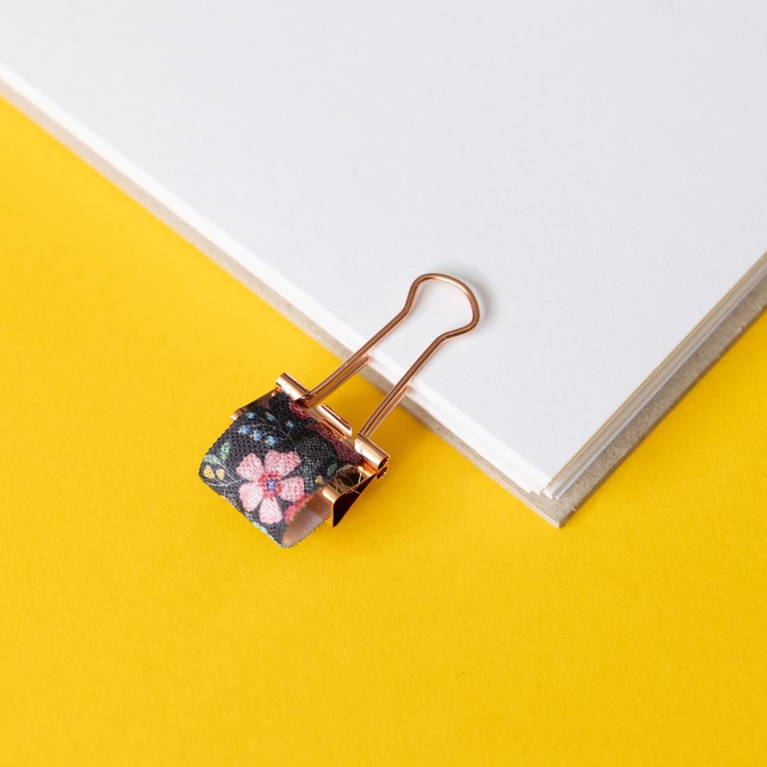 Floral-patterned paper clip on a yellow background