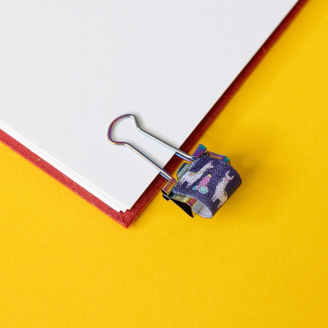 Decorative llama paper clip on a notebook with a yellow background